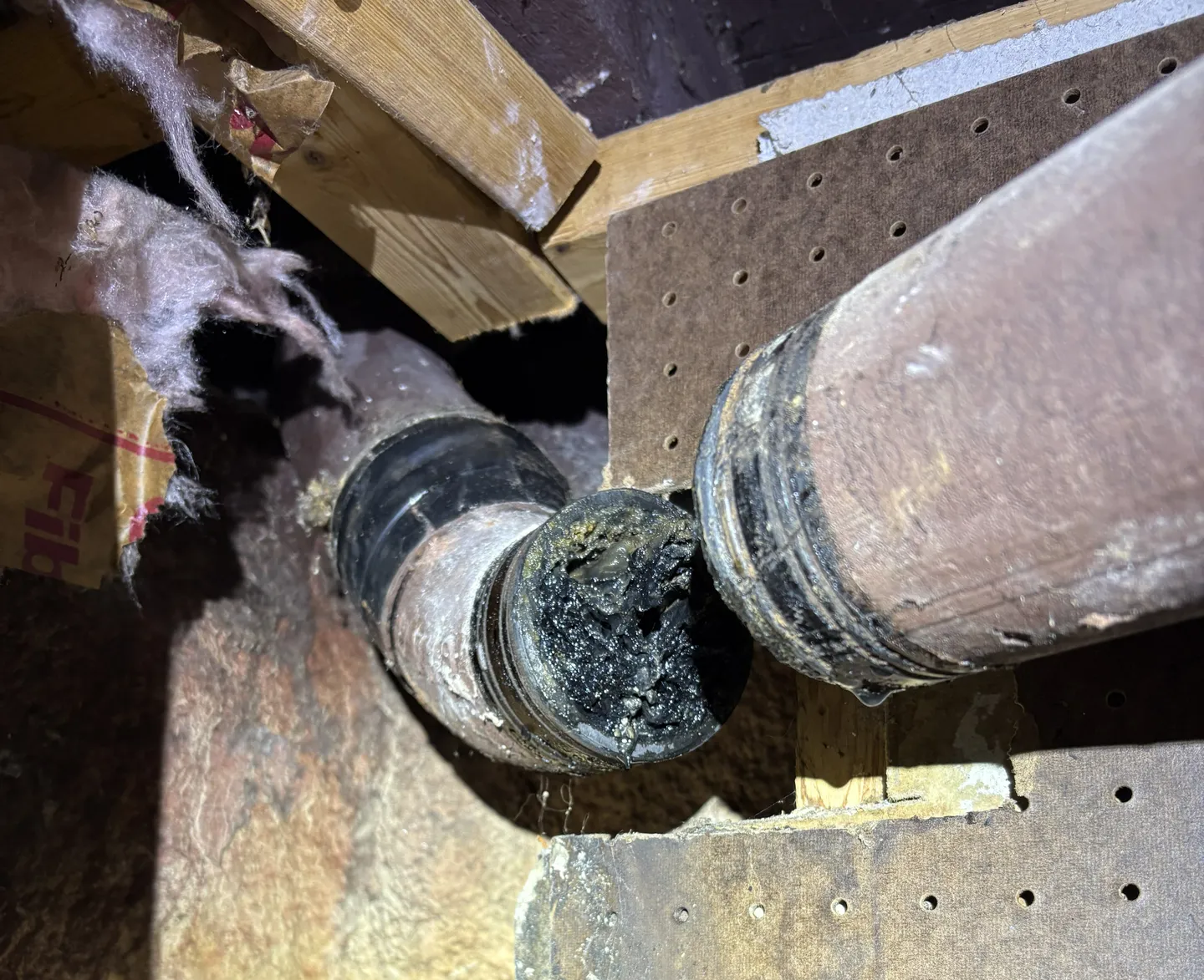 Corroded and deteriorating cast iron sewer pipe showing damage and buildup in a Massachusetts home
