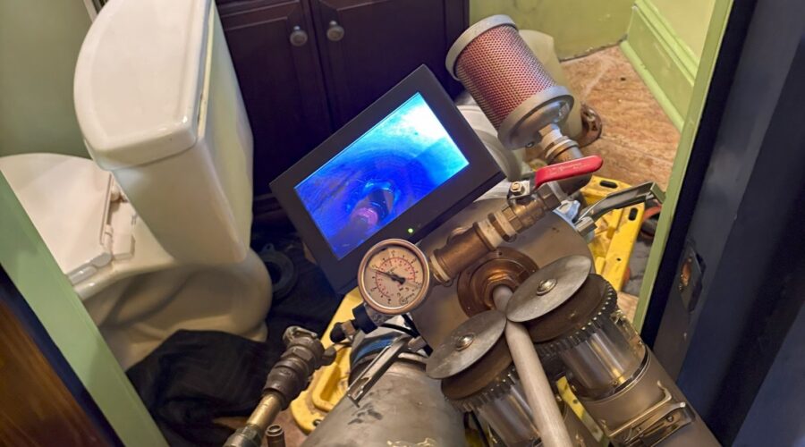 TID Trenchless technician performing a sewer camera inspection inside a residential bathroom in Southeastern Massachusetts