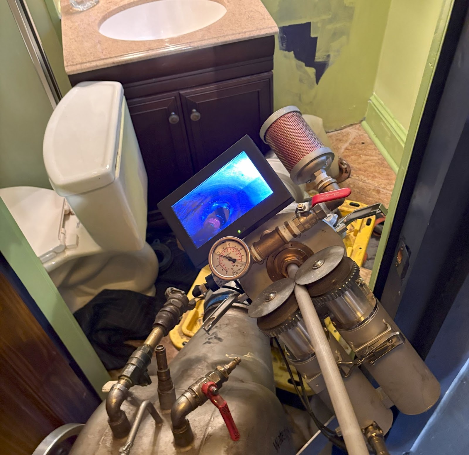 TID Trenchless technician performing a sewer camera inspection inside a residential bathroom in Southeastern Massachusetts