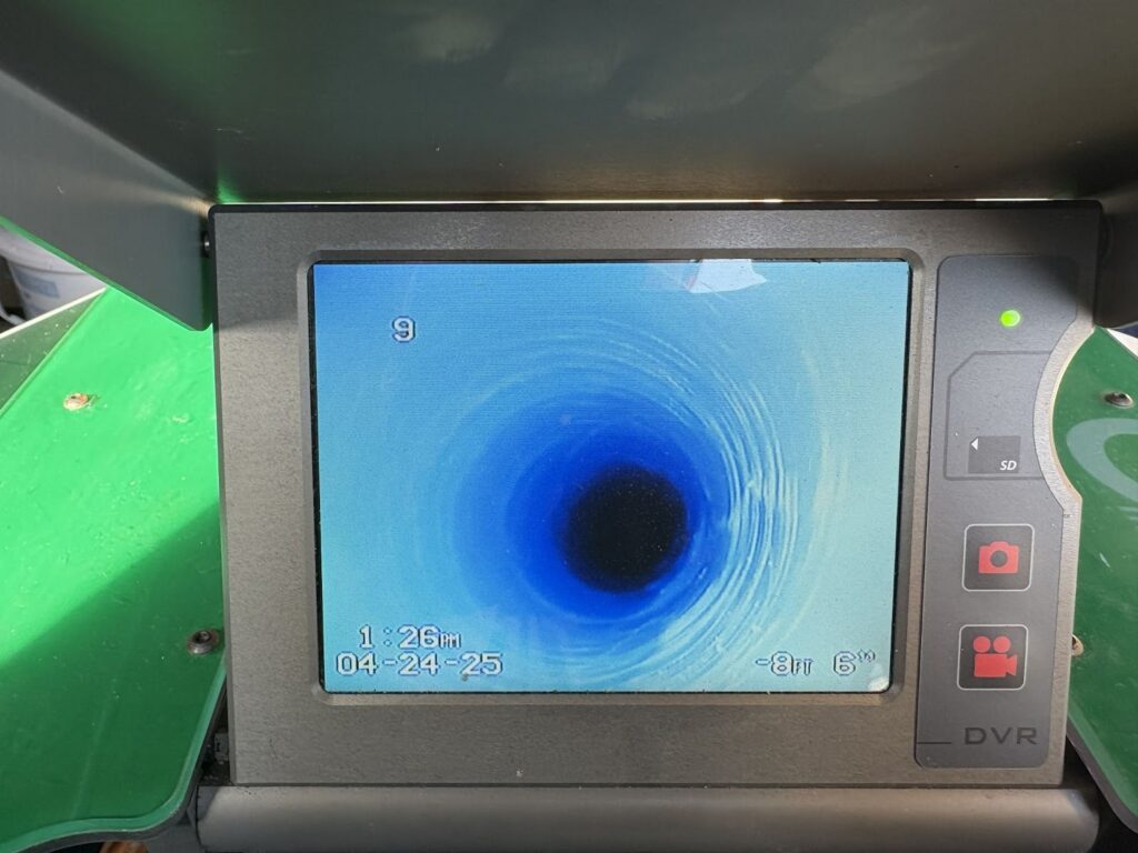 Sewer camera inspection monitor displaying the interior of a residential pipe during a professional diagnostic inspection
