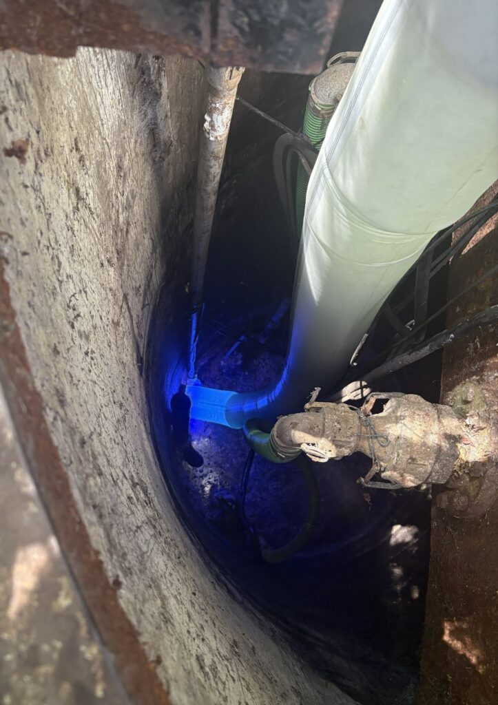 Interior view of a corroded sewer pipe during trenchless pipe lining installation showing rust and pipe damage