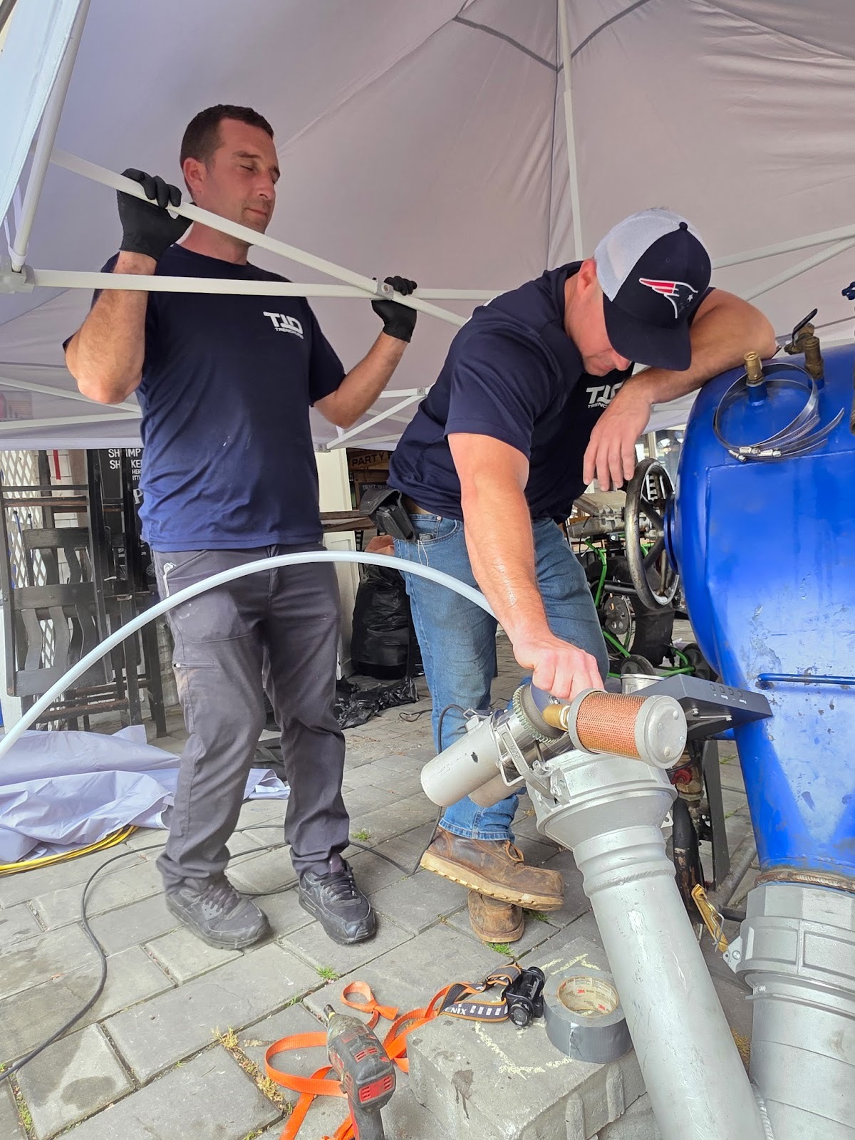 Technicians performing trenchless sewer repair using pipe lining equipment in MA