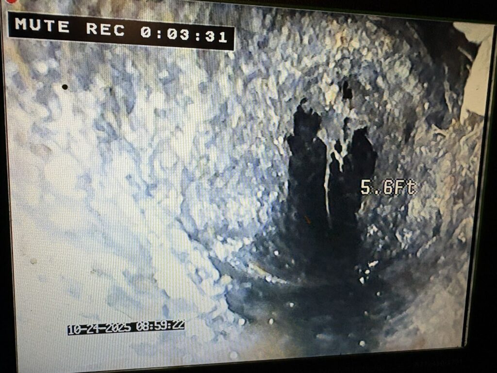 Camera inspection showing severe buildup causing a clogged drain inside a sewer pipe