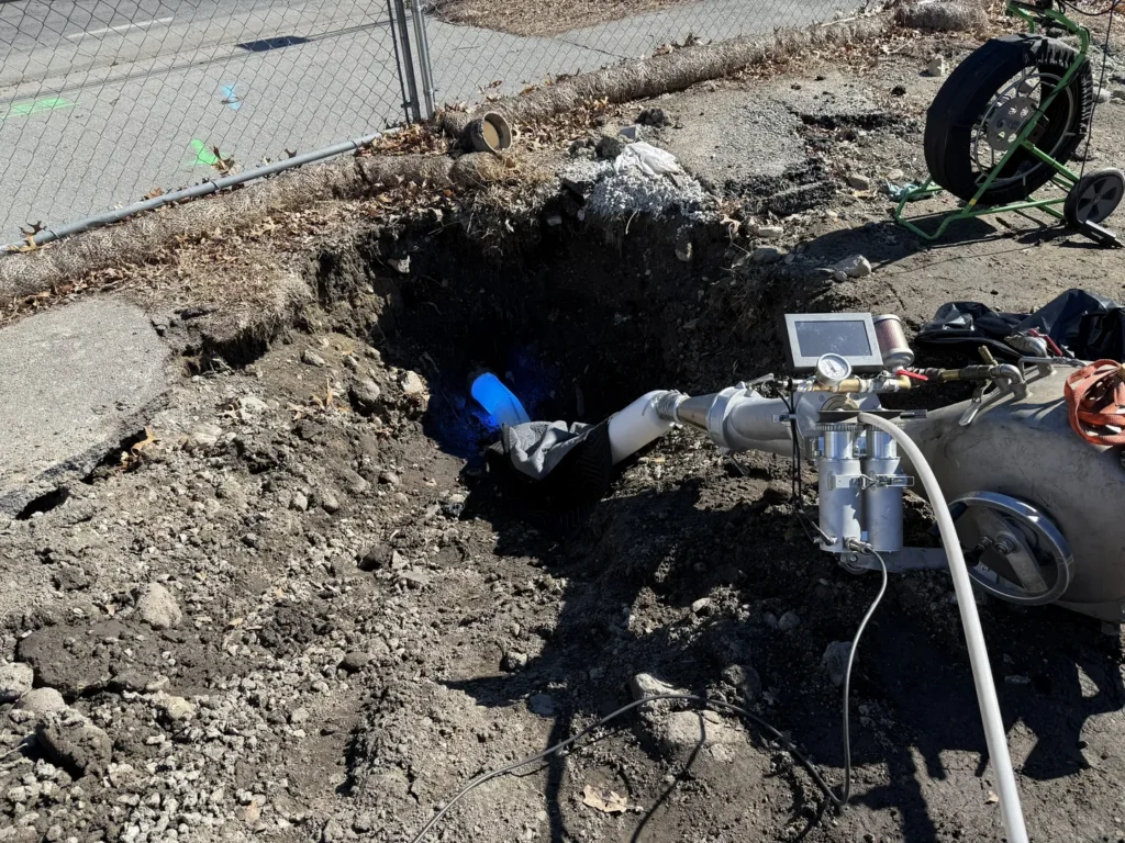 TID Trenchless pipe lining equipment at an excavated access point during a no dig sewer line repair in Massachusetts
