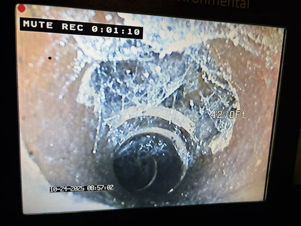 Sewer camera inspection footage showing severe pipe corrosion and scale buildup at 42 feet inside a residential sewer line in Massachusetts