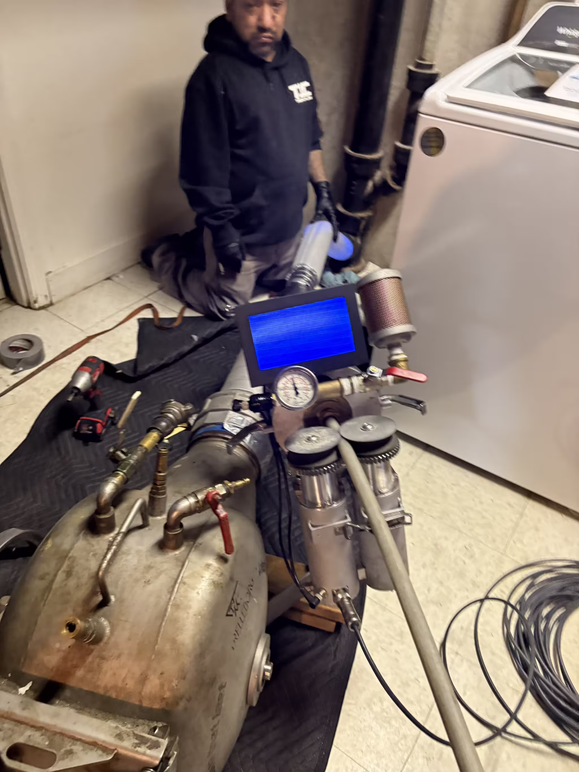 TID Trenchless technician preparing trenchless sewer repair equipment for a pipe lining job in a Massachusetts home