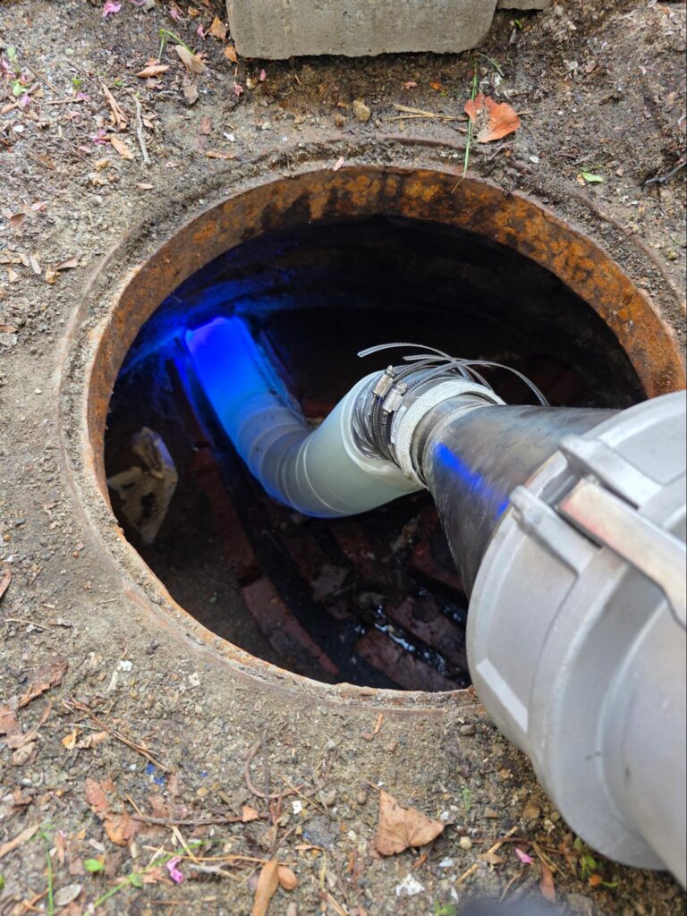 CIPP sewer liner being installed through a single manhole access point on a Newton, MA sewer line.