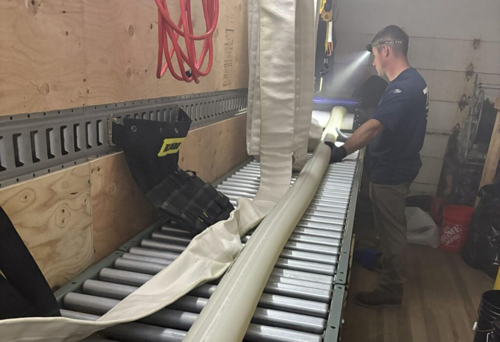 TID Trenchless technician saturating a sewer pipe liner with resin before installation.