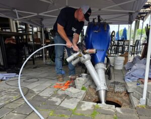TID Trenchless technician installing a sewer pipe lining with an inversion drum on site.