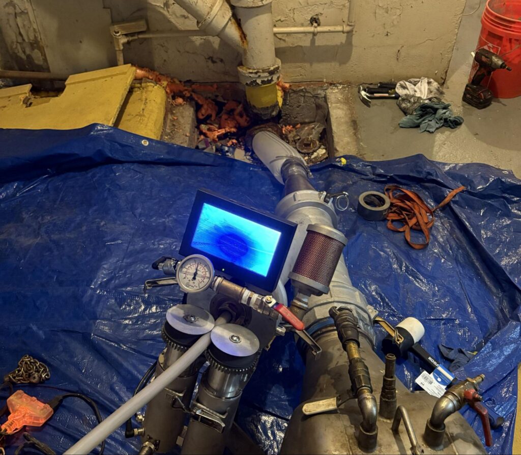 Basement sewer pipe lining setup with camera monitor, the process TID Trenchless uses in Newton, MA